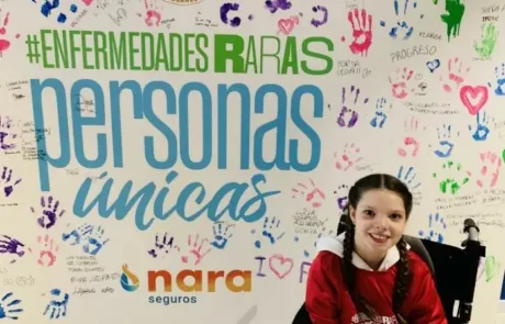 Carolina in front of the “#EnfermedadesRaras, personas únicas” wall signed by C.D. Leganés supporters.