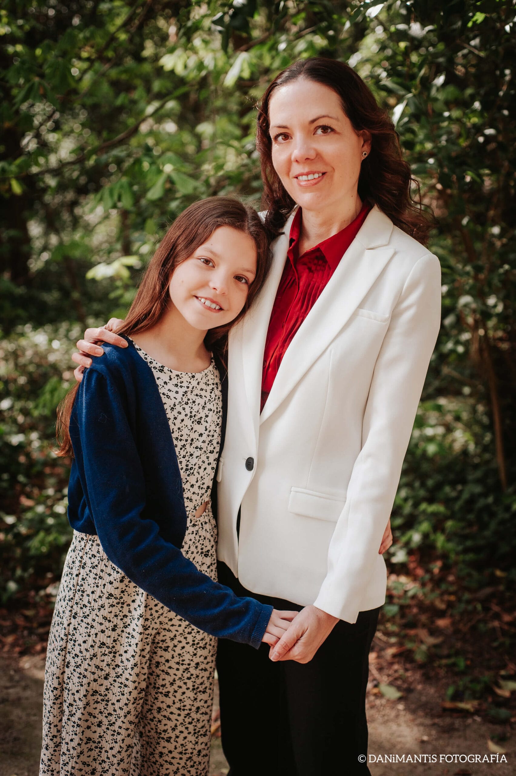 Laura and Isabel, mother and daughter and authors of Carolina Purpurina, pose together in a garden.