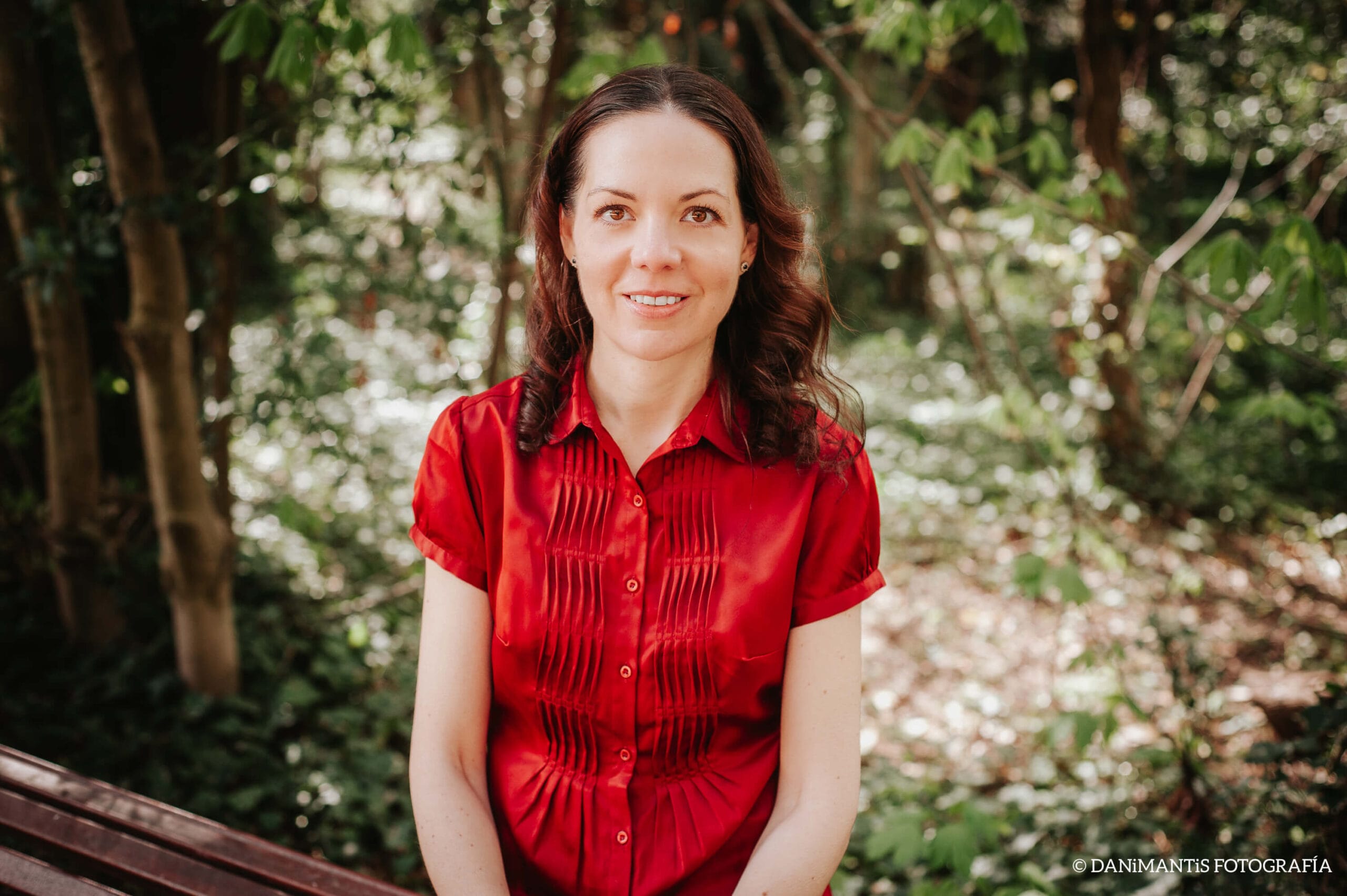 Portrait of Laura, co-author of Carolina Purpurina, in a red blouse in the garden.