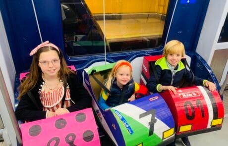 Carolina and her siblings ride the metro in their bumper-car costumes on the way to the contest.