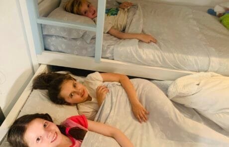 Carolina and her siblings at bedtime, in the bunk beds of their bedroom.