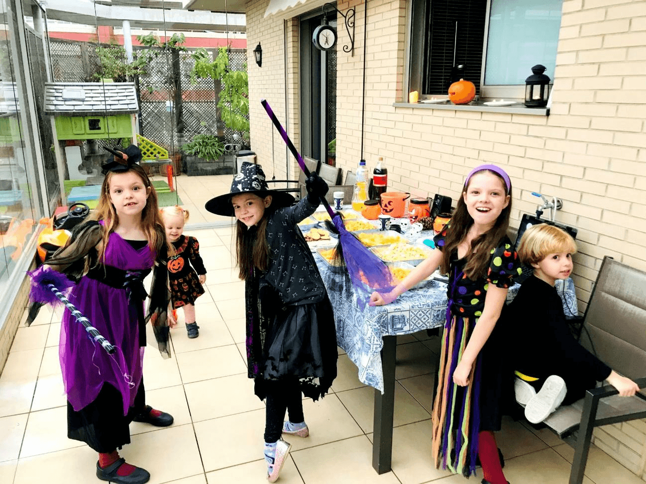 Carolina Purpurina’s birthday party: children in witch costumes around a table decorated with pumpkins.