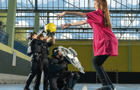 Photograph from the 2024 ELA calendar: Carolina throws a ball to Guardia Civil officers in a sports hall.