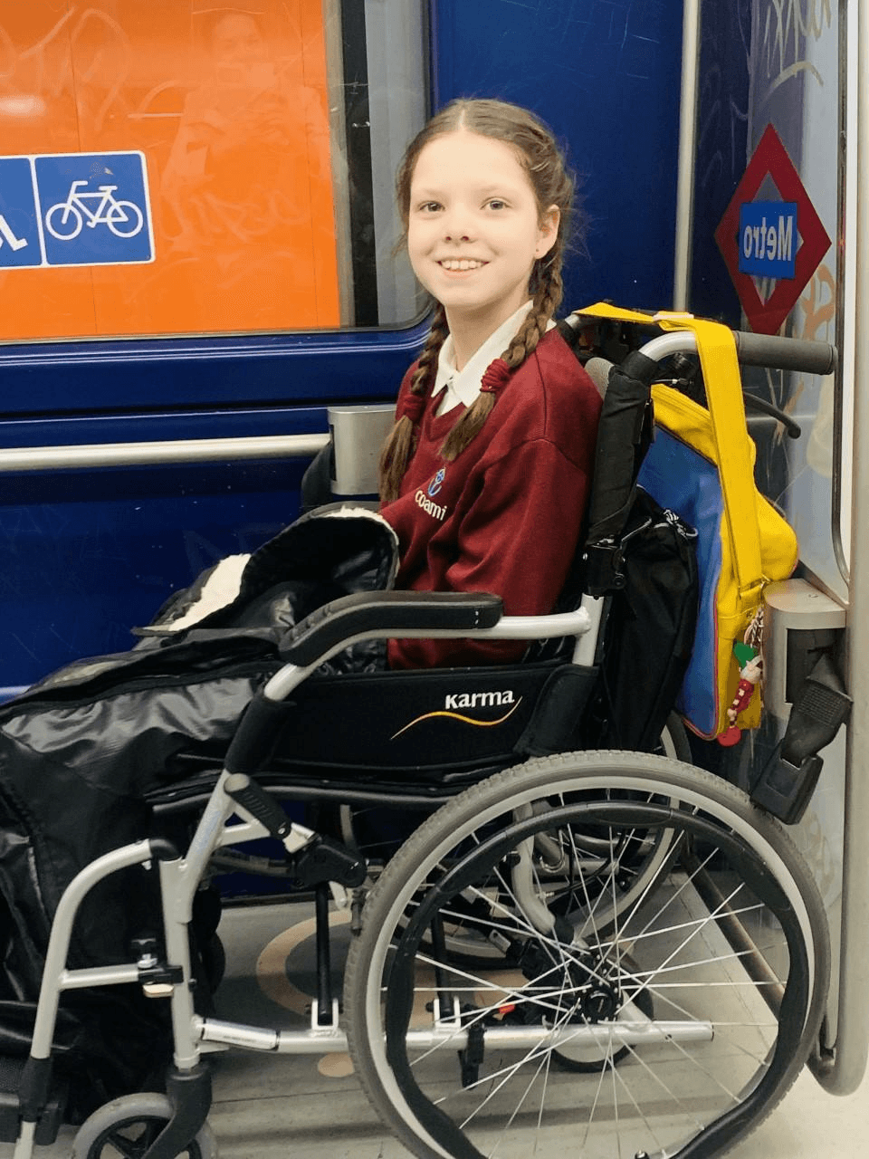 Carolina, in her wheelchair and school uniform, travels on the Madrid metro every day.