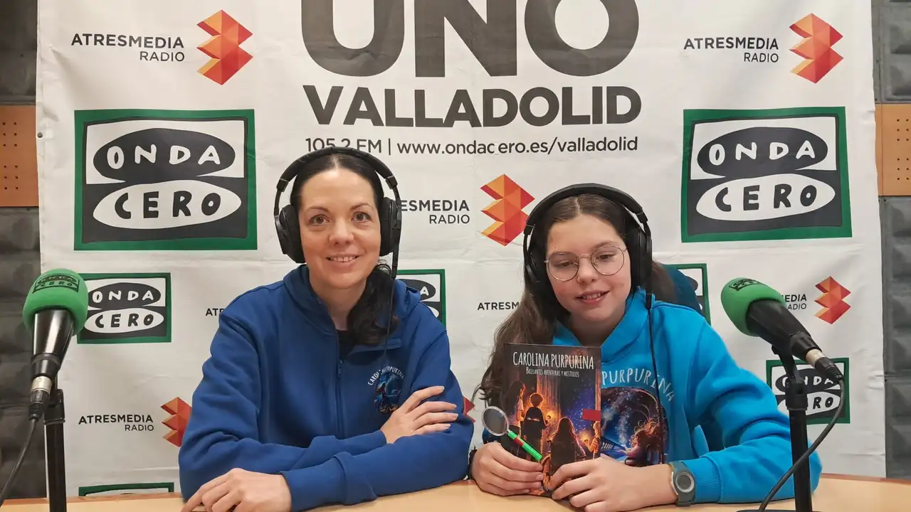 Laura and Isabel, wearing headphones, in the Onda Cero Valladolid studio with the book.