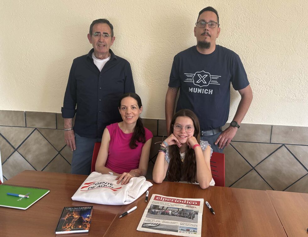 Laura and Isabel during the interview for Infoguadiato, the book and newspaper on the table.