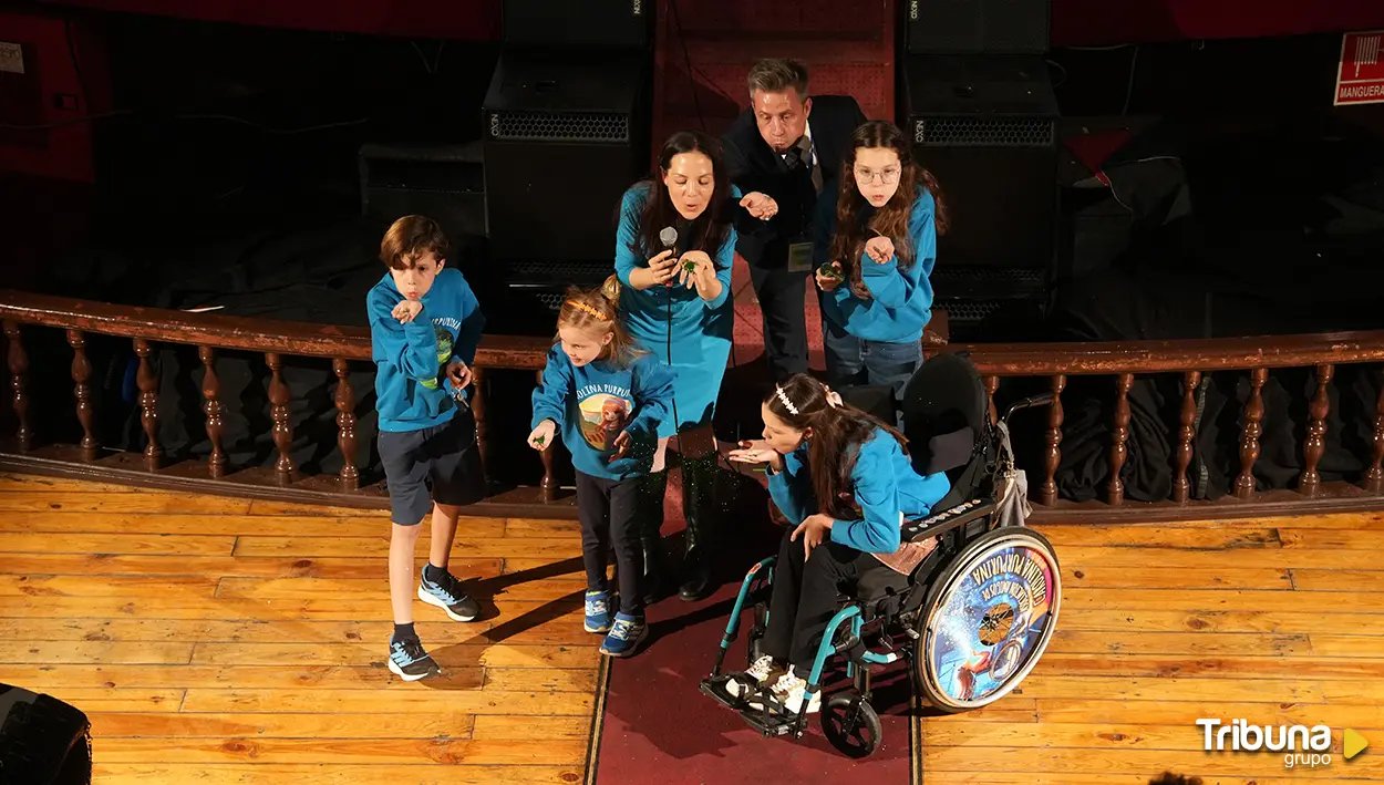 Renacer Carbono gala: Carolina, in her wheelchair, Isabel and others on stage blow glitter from the palms of their hands.